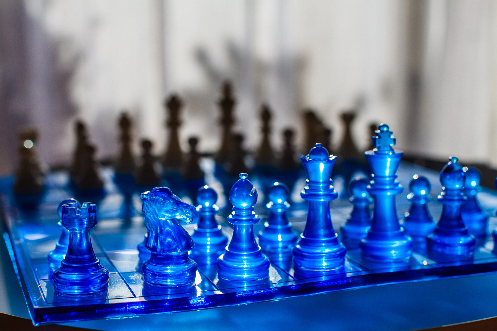 Blue crystal chess pieces facing a shadowed opponent — the strategic stakes of Dr. Light's Devious Doomsday Device.